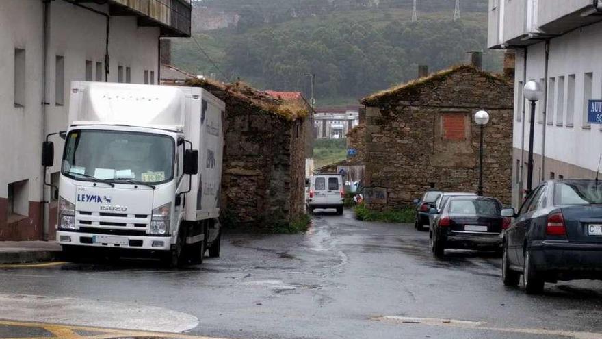 Varios vehículos aparcados junto a las casas en ruinas de As Eiras, en Meicende.