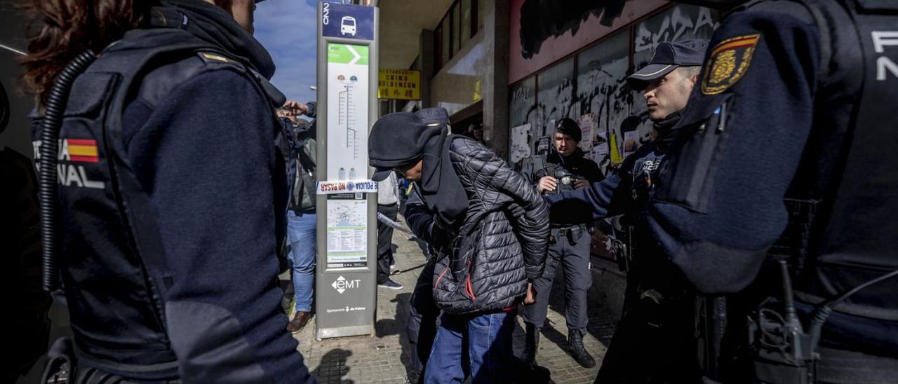 Un agente de la Policía Nacional lleva detenido a un miembro de la banda juvenil.