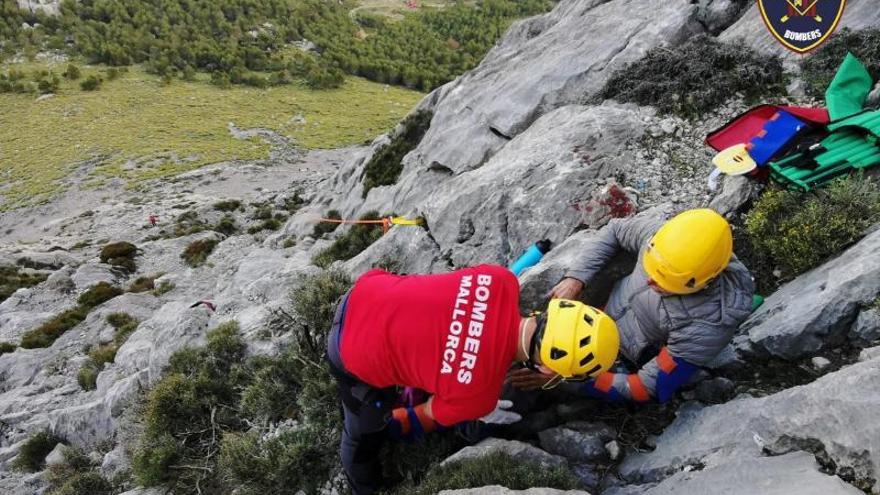 Un bombero asiste a un escalador de 69 años que resultó herido en el Pa de Figa de Son Torrella. 