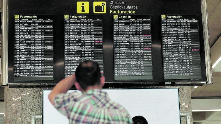 Un pasajero revisa la pantalla, con vuelos cancelados por huelga, en Son Sant Joan este verano. | MANU MIELNIEZUK
