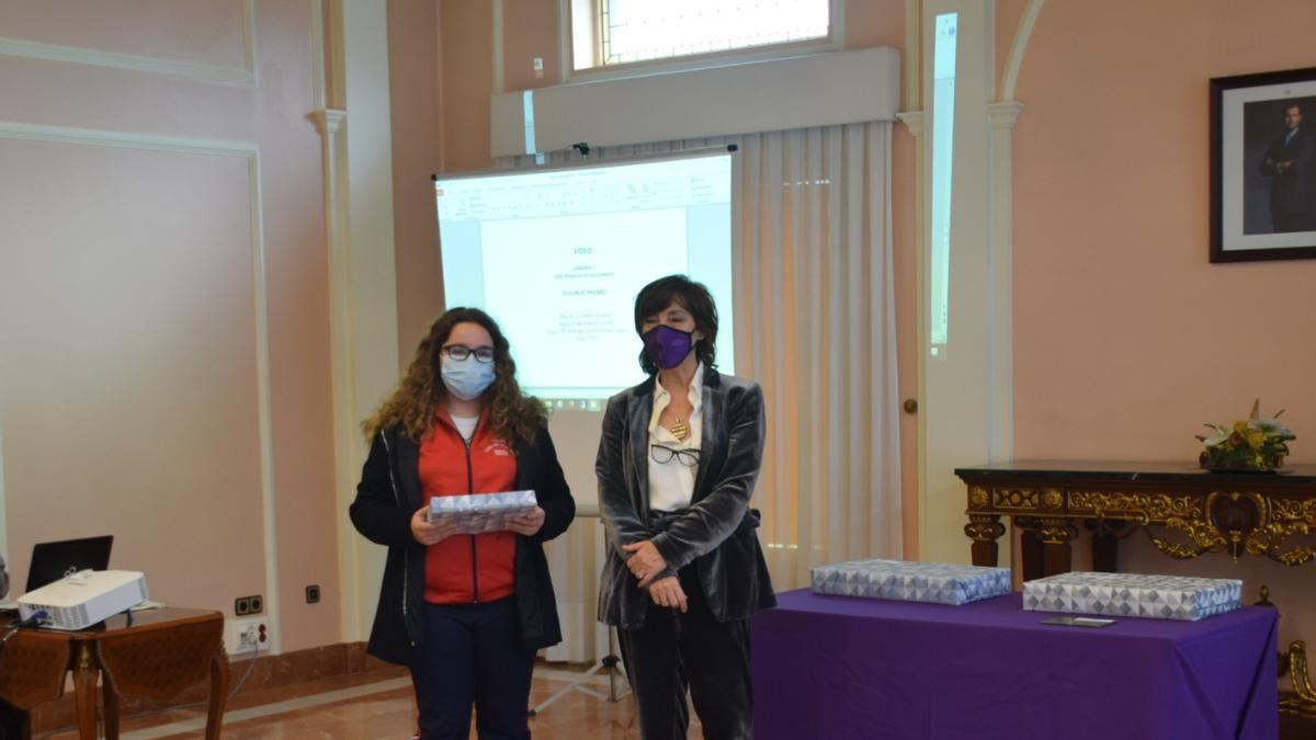 La estudiante premiada recibiendo el regalo.