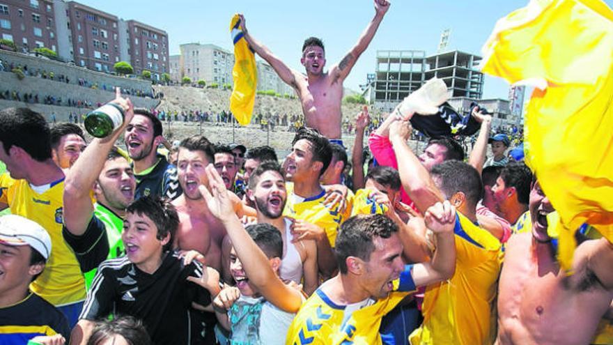 Los jugadores del filialy los aficionados festejan el ascenso con el canterano Artiles a hombros