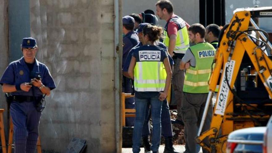 Varios policías se apiñan ante uno de los zulos en Son Banya en el momento de ser descubierto.