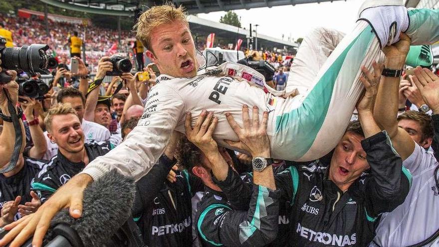 Nico Rosberg, manteado por los integrantes de su equipo, celebra el título mundial de Fórmula 1. // Efe