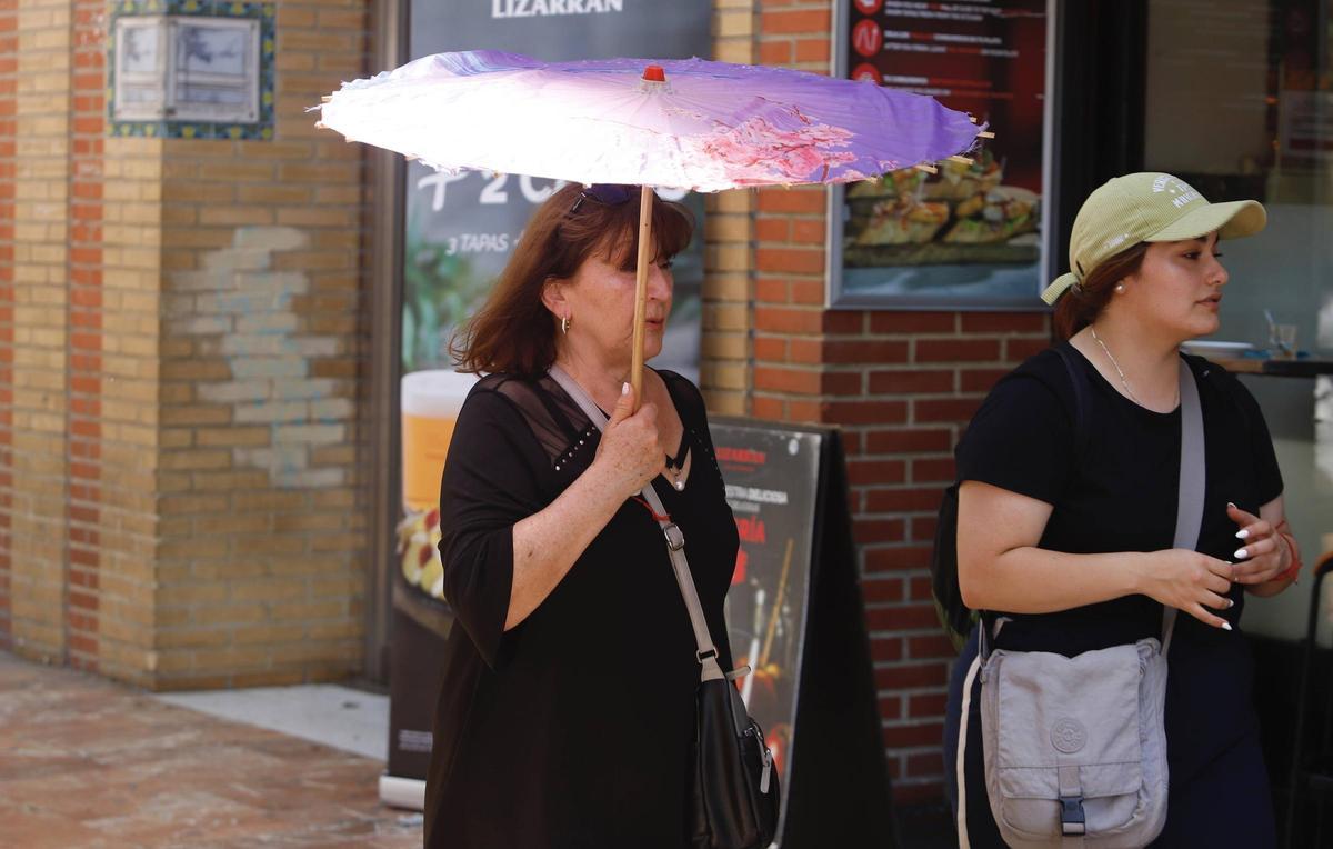 Una mujer protegiéndose del sol en València este fin de semana.