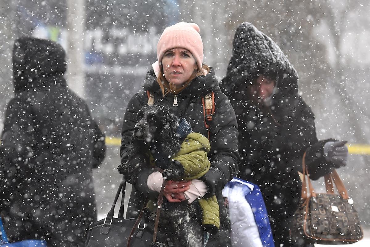 Refugiados ucranianos cruzan la frontera bajo una intensa nevada en Siret, Rumania.