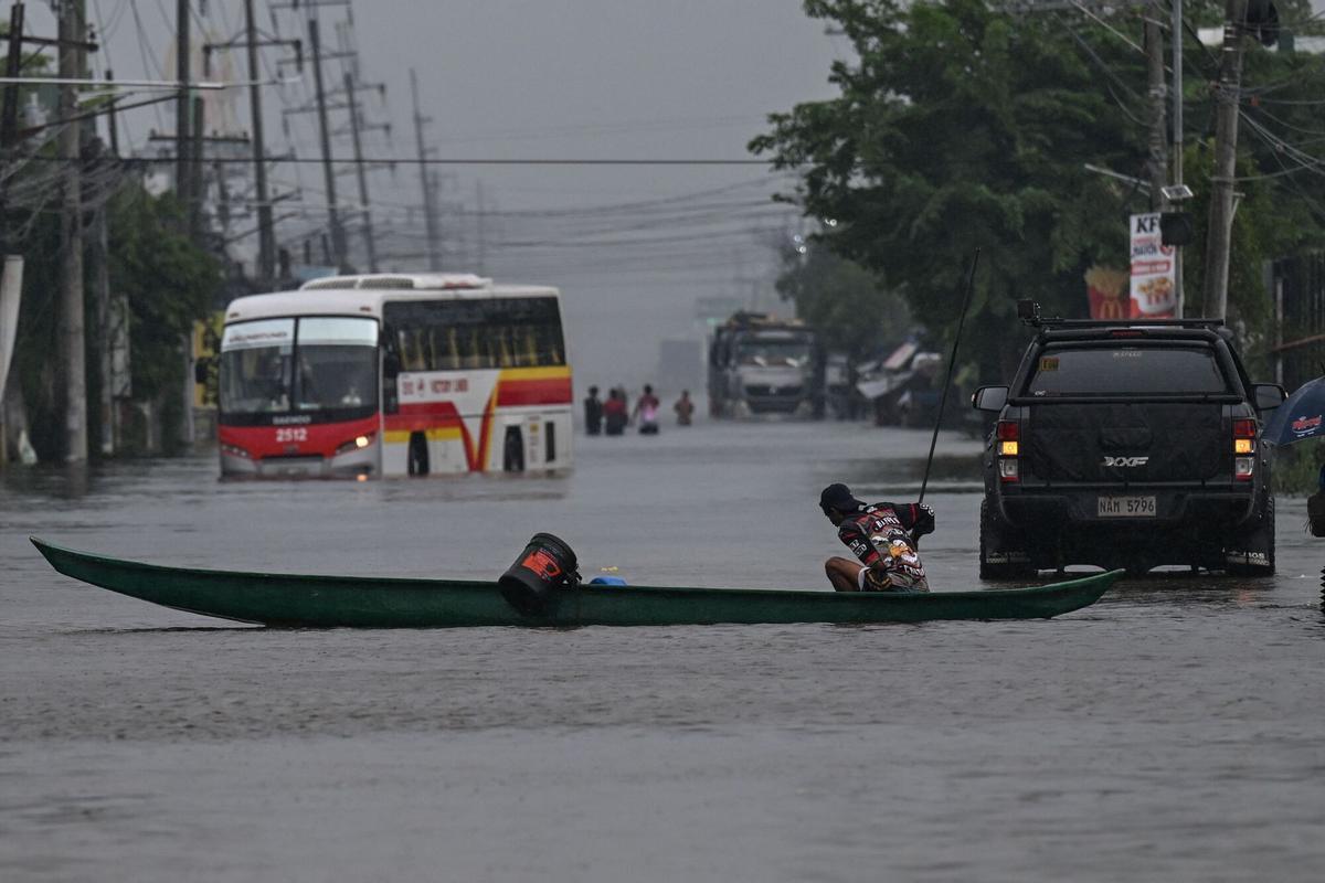 Los automovilistas viajan a través de una calle inundada debido a las lluvias traídas por el monzón del suroeste en Pampanga el 31 de agosto de 2026. (Foto de Jam STA ROSA / AFP)