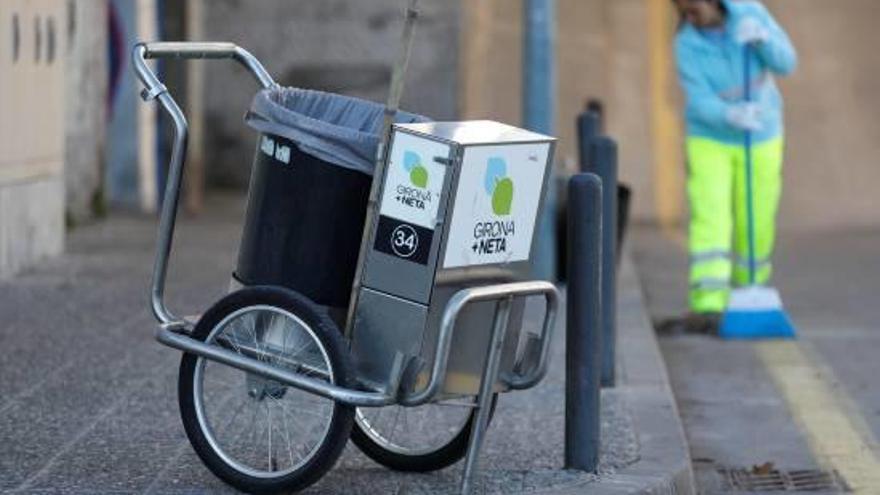 Una operària netejant ahir a peu un carrer de Girona.