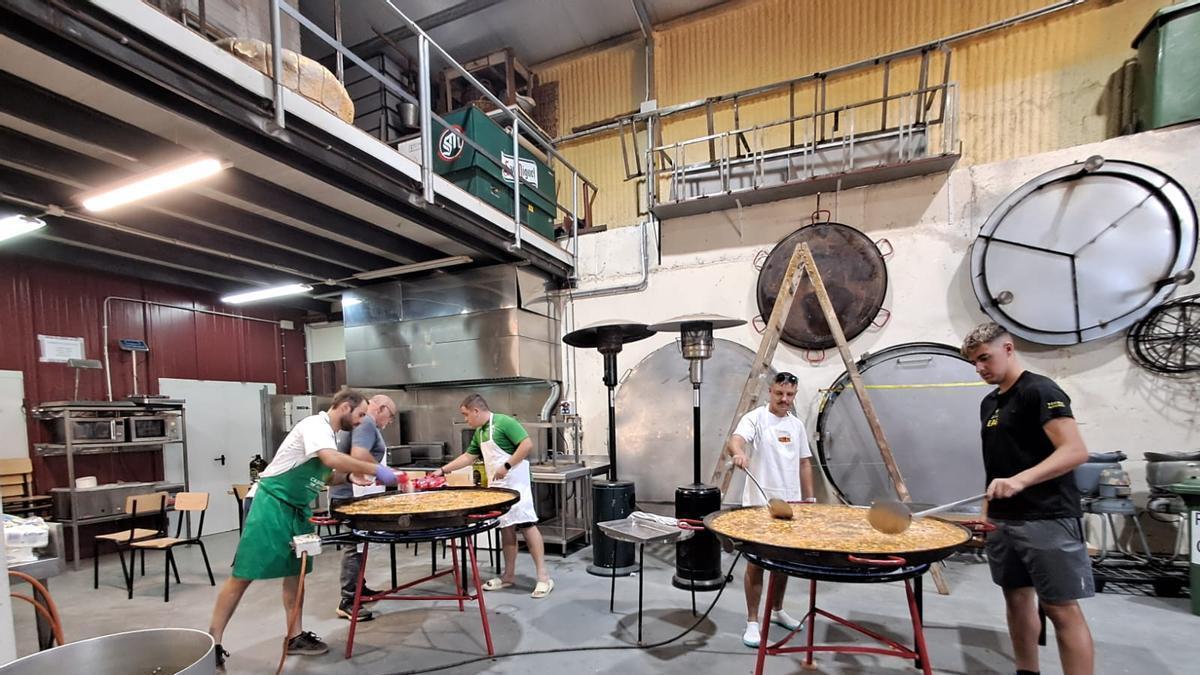 Vecinos de Albelda preparando una paella de arroz con carne para 300 personas.