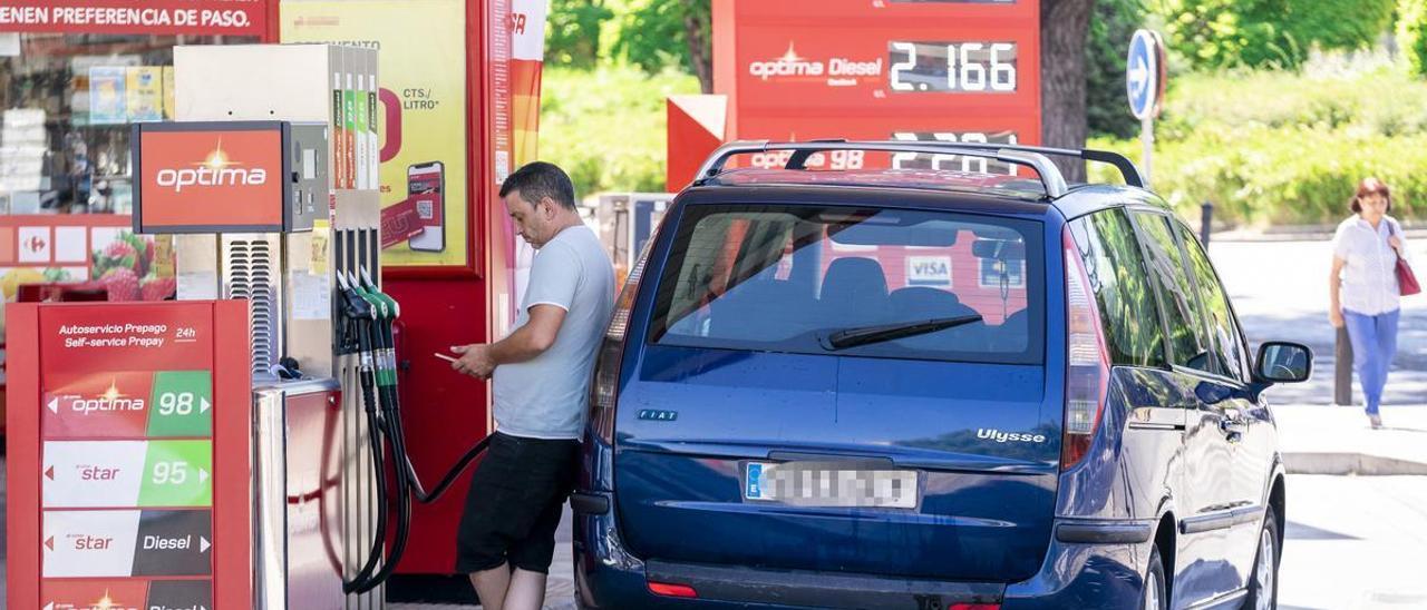 Un hombre reposta su vehículo en una gasolinera.