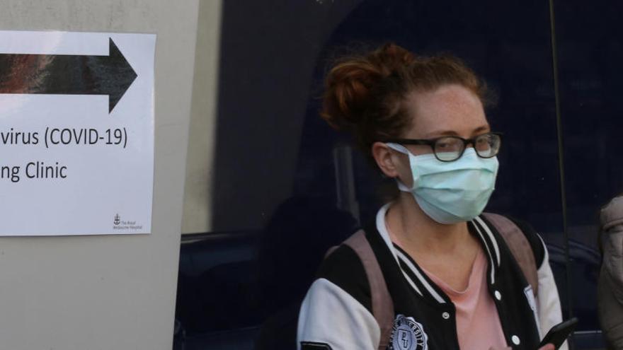 Una dona amb mascareta, davant un hospital a Melbourne