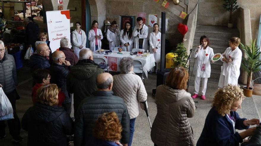 Las profesionales sanitarias se dirigen a los asistentes en el Mercado de Pontevedra.