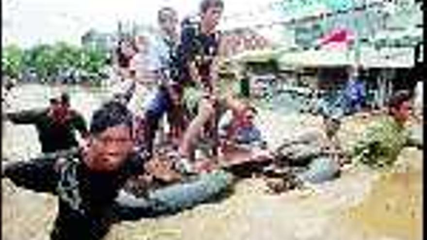 Ciudadanos indonesios son remolcados por un equipo de rescate en Yakarta. / Mast Irham