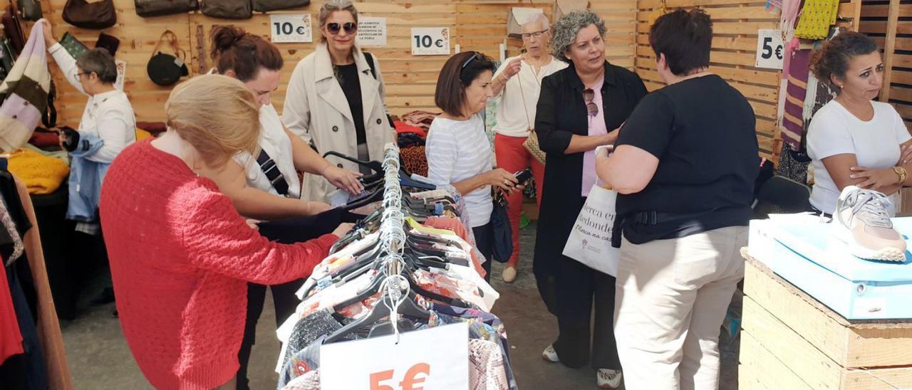 Unas personas contemplan la ropa en uno de los puestos de la Feria de Oportunidades de Redondela, ayer.  // MARTA G. BREA