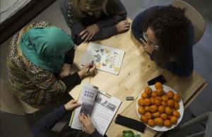 Dos técnicas de Creu Roja imparten una clase de catalán en la Casa Bloc de Barcelona a dos refugiadas.