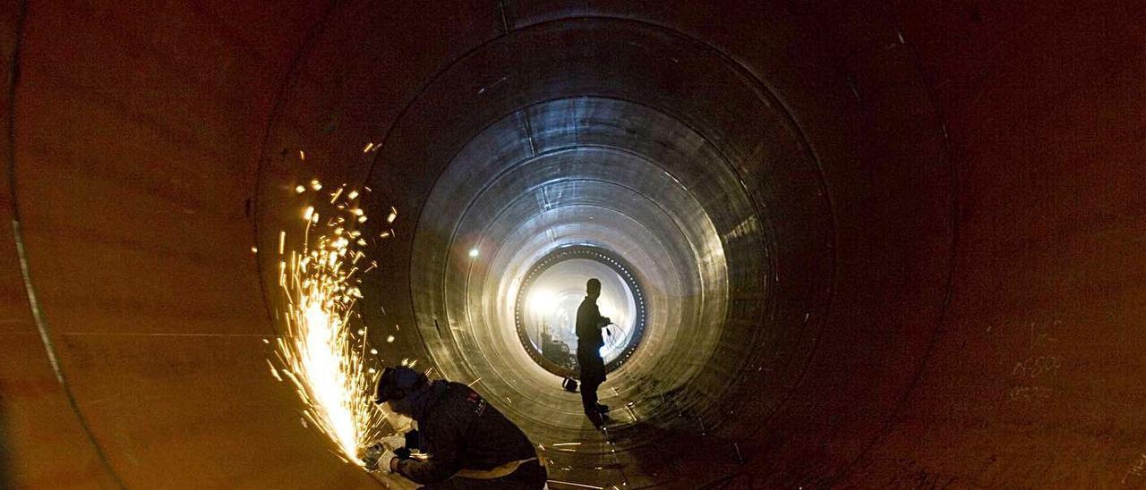 Especialistas rebajando una soldadura en el interior de un fuste de torre eólica de Windar. | Miki López