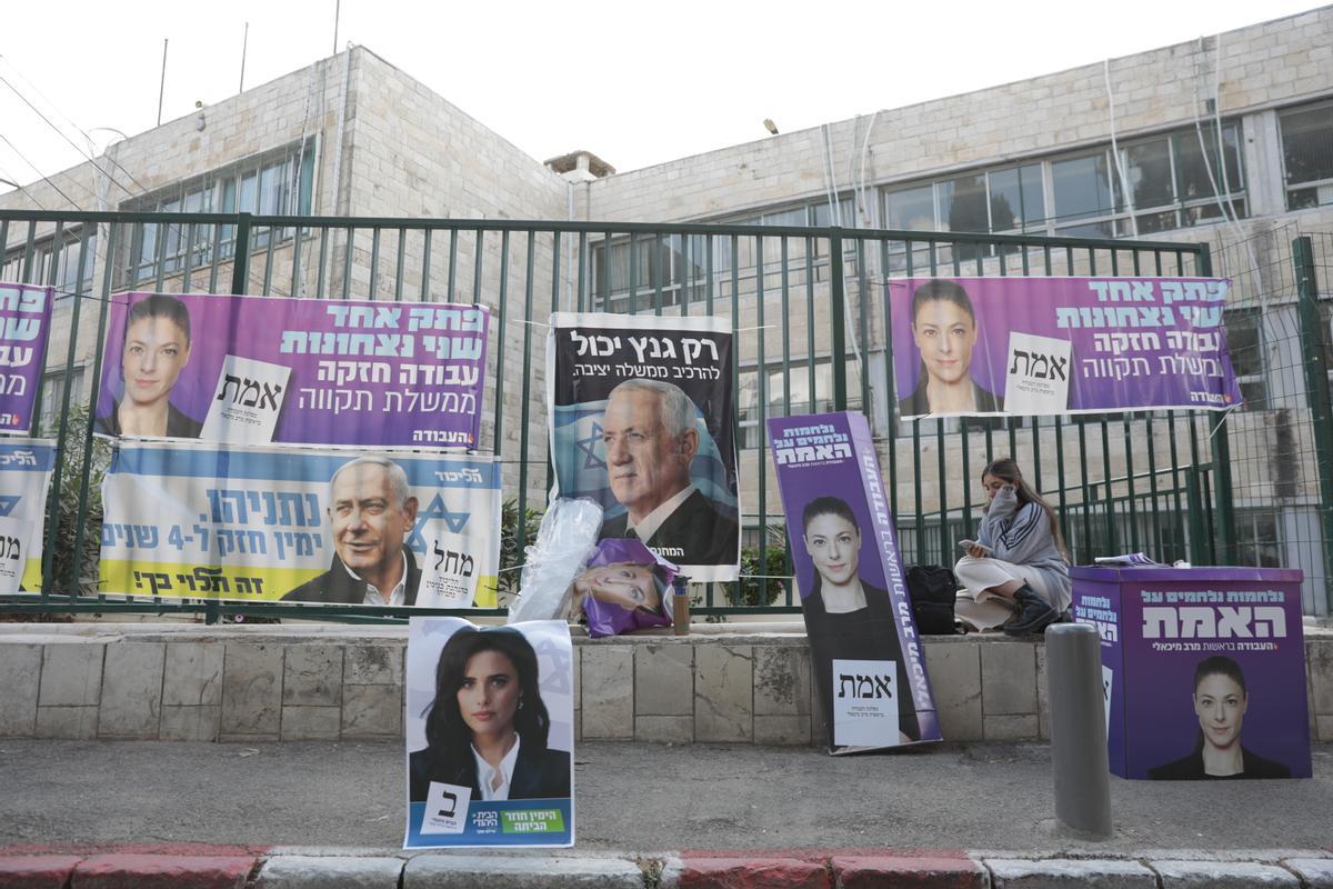 Una mujer se sienta junto a los carteles electorales durante las elecciones generales israelíes en Jerusalén, Israel.Los israelíes se dirigen a las urnas para elegir a los 120 miembros del 25º Knesset, o parlamento , durante las quintas elecciones generales celebradas en cuatro años.