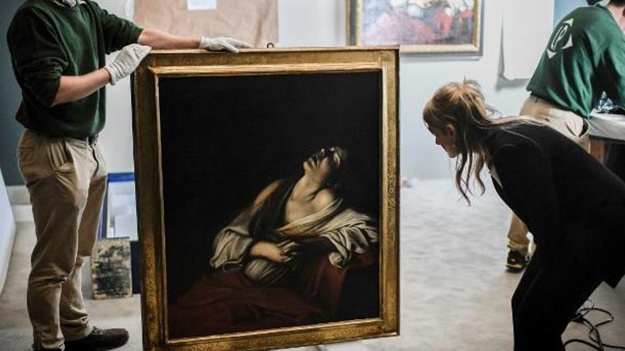 Un trabajador sostiene un cuadro de Caravaggio.