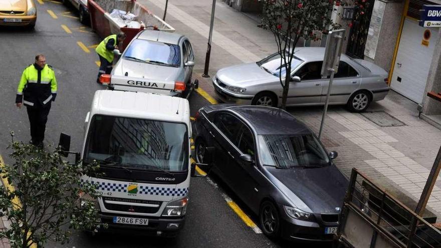 La grúa retirando un vehículo mal estacionado ante un vado en la calle García Camba. // Gustavo Santos