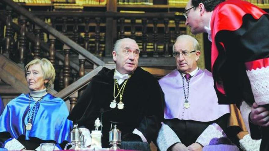 El secretario general, José Francisco Fernández, con muceta roja, habla con el rector, Vicente Gotor, durante el acto de Santa Catalina. A su lado, la nueva vicerrectora de Campus de Excelencia Internacional, Paz Suárez Rendueles, y el vicerrector de Profesorado, Julio Antonio González.