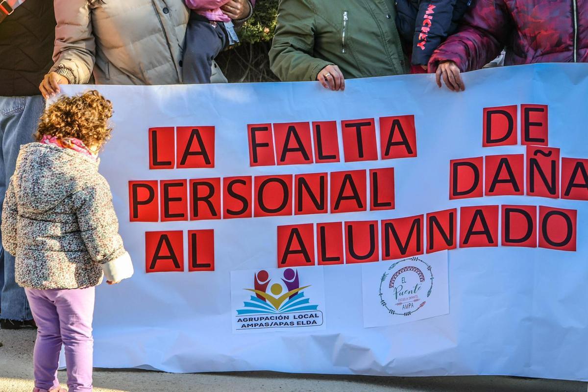 Padres y madres sostienen una pancarta que han exhibido en la concentración.