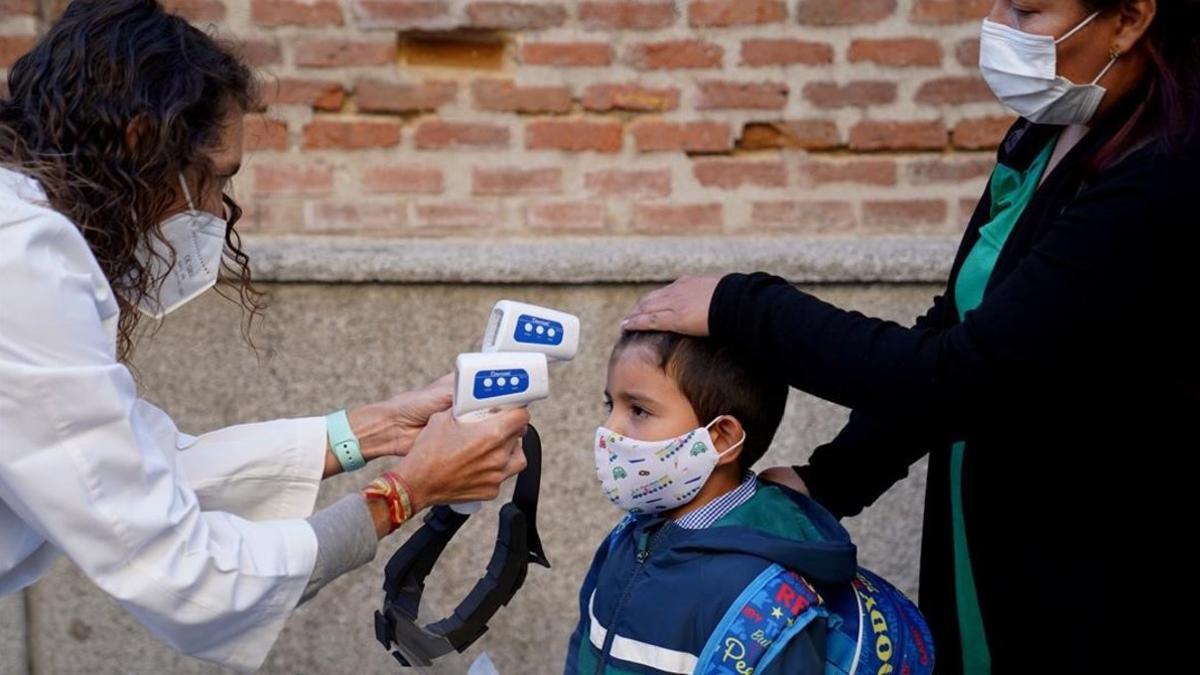 Un niño entra en un cole de Madrid después de tomarle la temperatura, hoy en Madrid