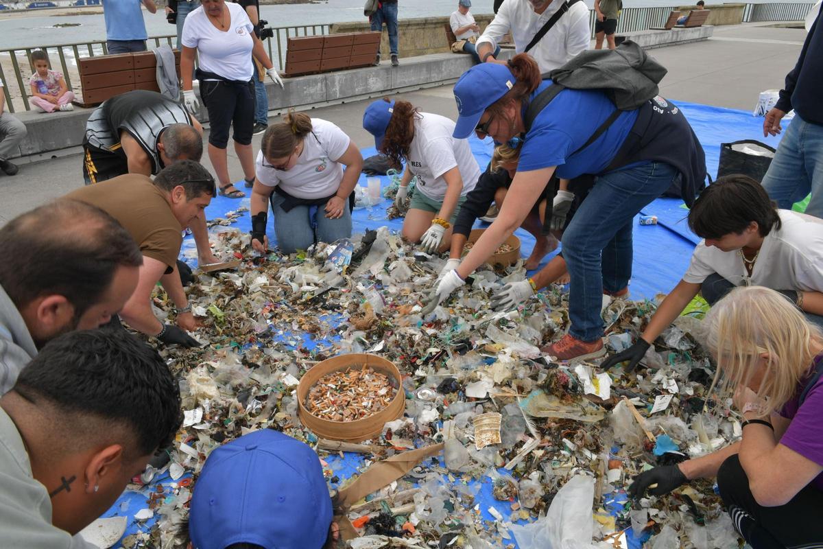 Voluntarios con la basura recogida en la limpieza de playas de este lunes