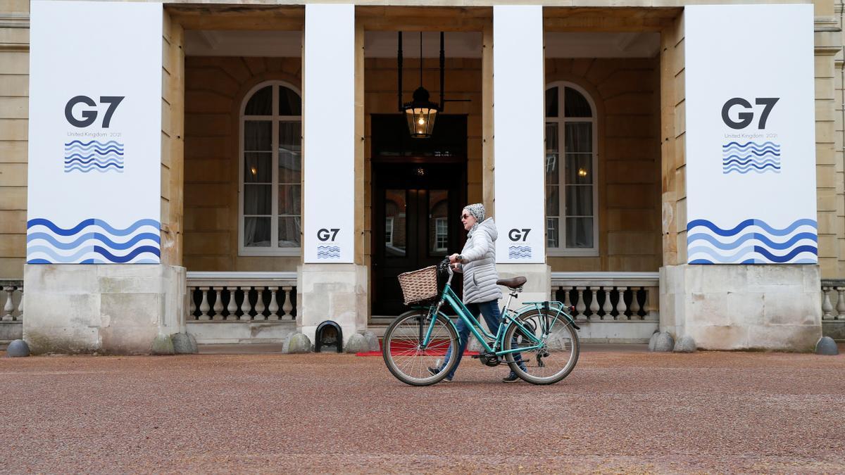 Una joven pasa por delante de Lancaster House, sede de la cumbre del G-7 en Londres.