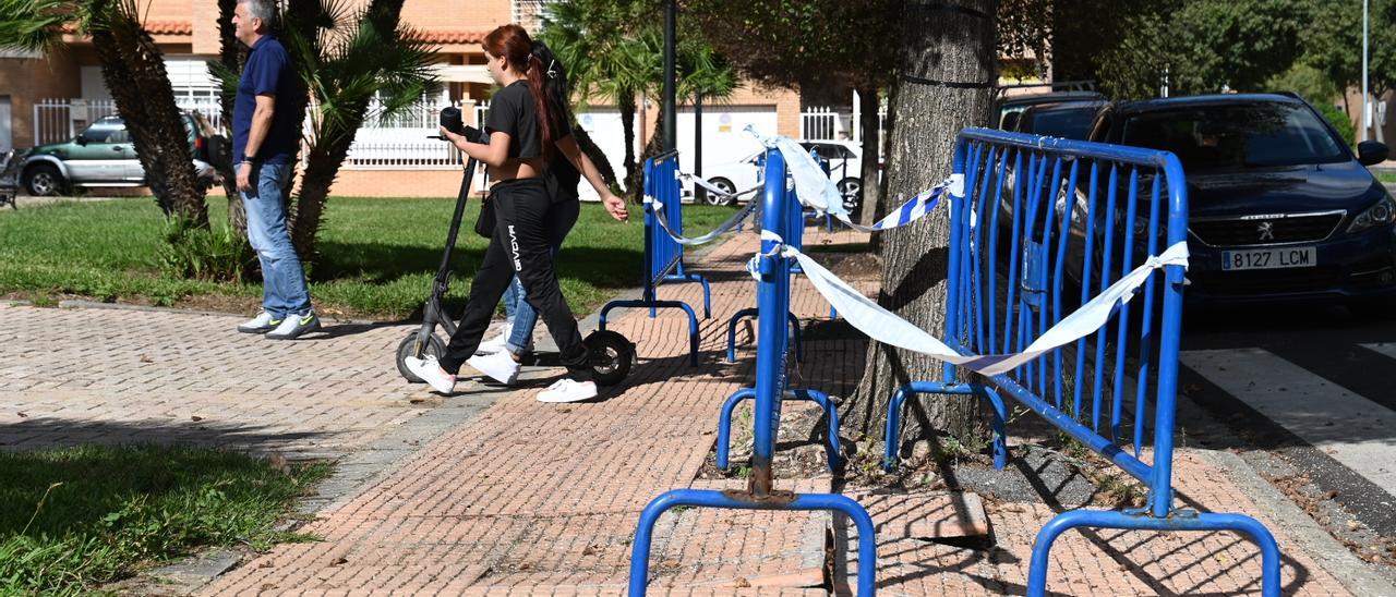 Las vallas advierten de que las baldosas están levantadas, cerca del parque infantil.