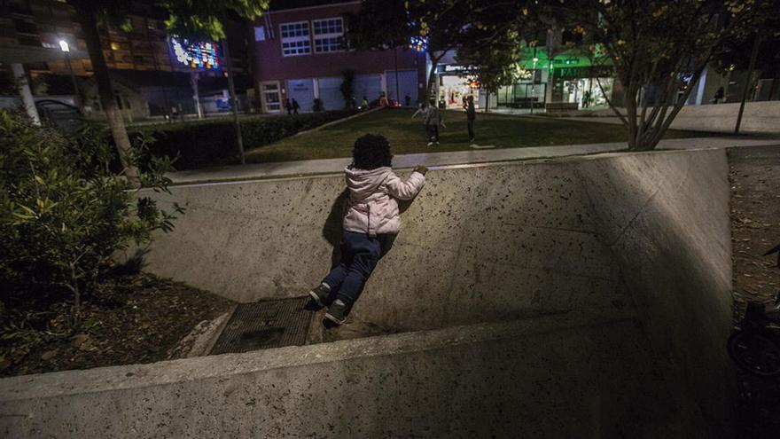 Una niña en la zona de la plaza que está peor iluminada.