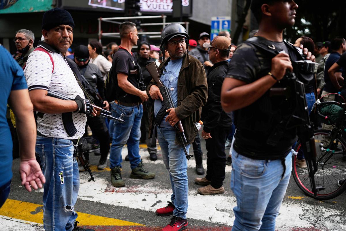 Pro-government armed civilians attend a protest demanding the release of President Nicolas Maduro and first lady Cilia Flores, the day after U.S. forces captured and flew them to the United States, in Caracas, Venezuela, Sunday, Jan. 4, 2026. (AP Photo/Ariana Cubillos). EDITORIAL USE ONLY/ONLY ITALY AND SPAIN