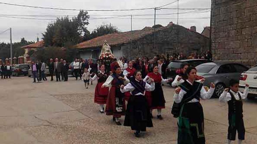 Jóvenes vestidas con trajes regionales procesionan con la Virgen.