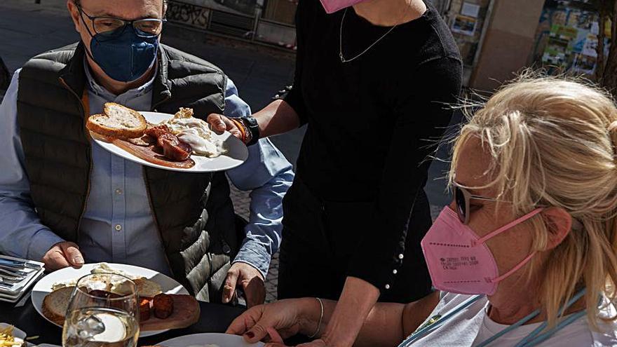 Una pareja, a punto de degustar el plato en una terraza. | J. Luis Fernández