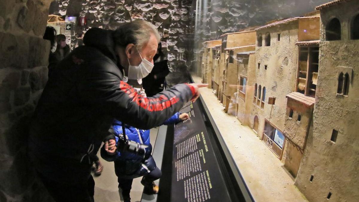 Un visitant ensenyant la maqueta animada de Manresa al seu net | JORDI BIEL