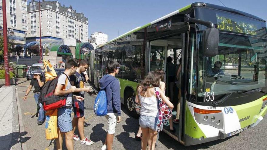 Varios jóvenes suben a un autobús de Vitrasa en Praza de América. // FdV