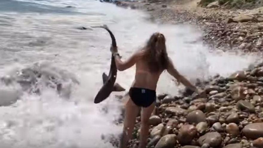 El gesto valiente de una chica al rescatar un tiburón varado en la playa