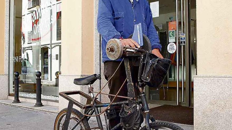 Tomás López con su bicicleta equipada para afilar y el chiflo.