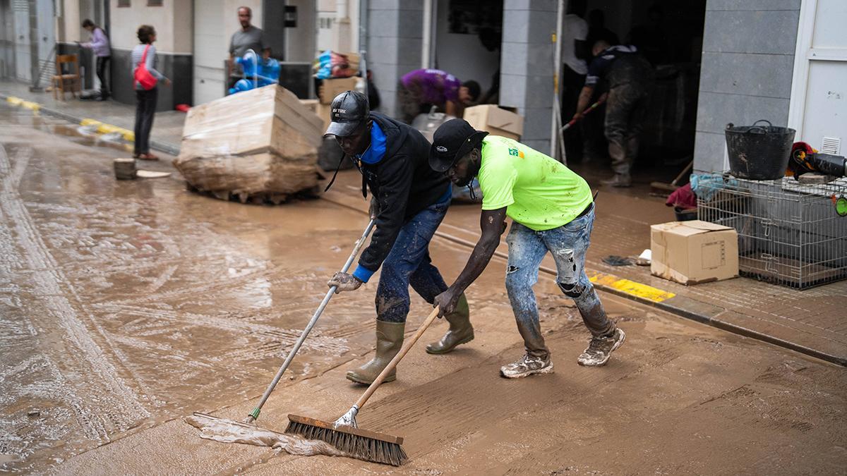 Vecinos de La Ràpita limpian calles y bajos de edificios cubiertos de lodo tras el paso de la DANA Alice.