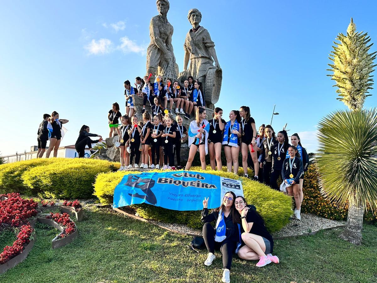 Las gimnastas ante la escultura de la familia mariscadora, esta tarde.