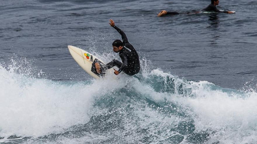 Un joven practica surf en una playa de la Isla.