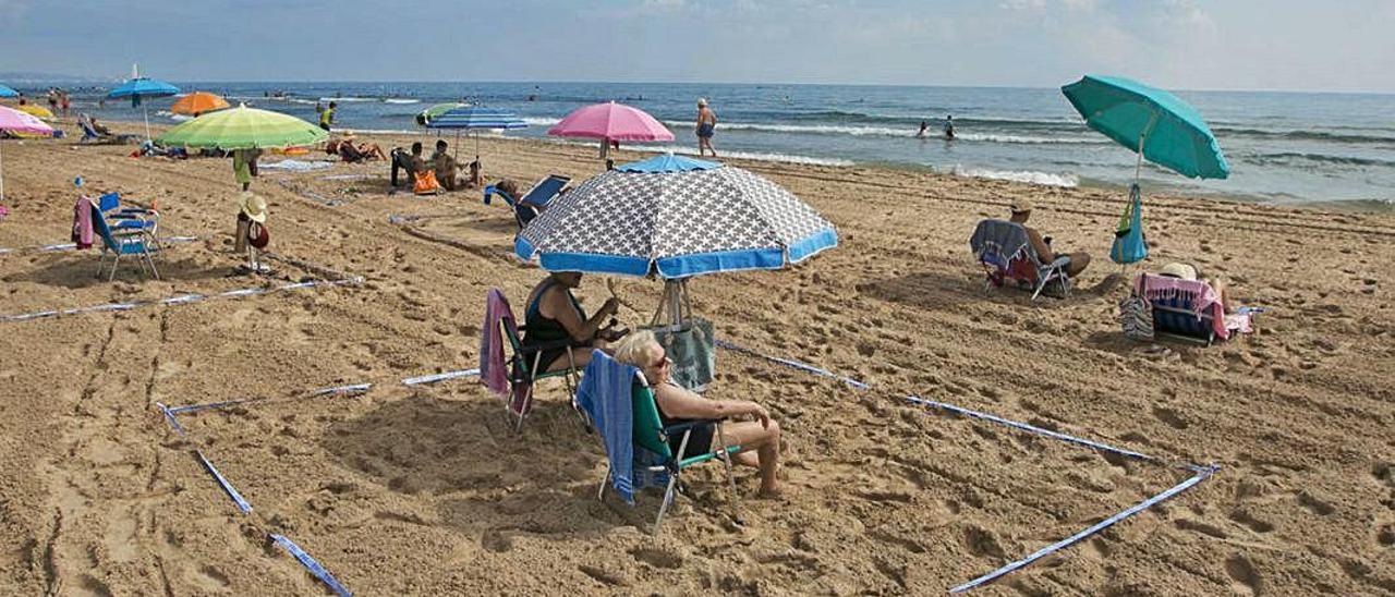 Bañistas tomando en sol en la playa de Gandia.