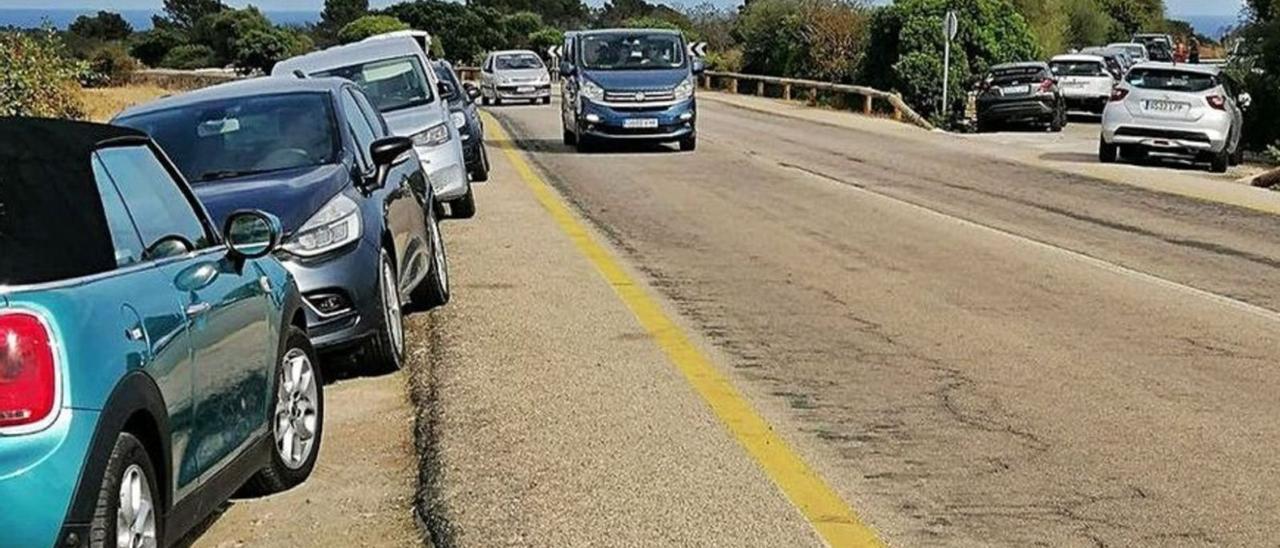 Fotografía del pasado verano de vehículos mal estacionados en ambos lados de la carretera. Una imagen que se repite año tras año. | DM