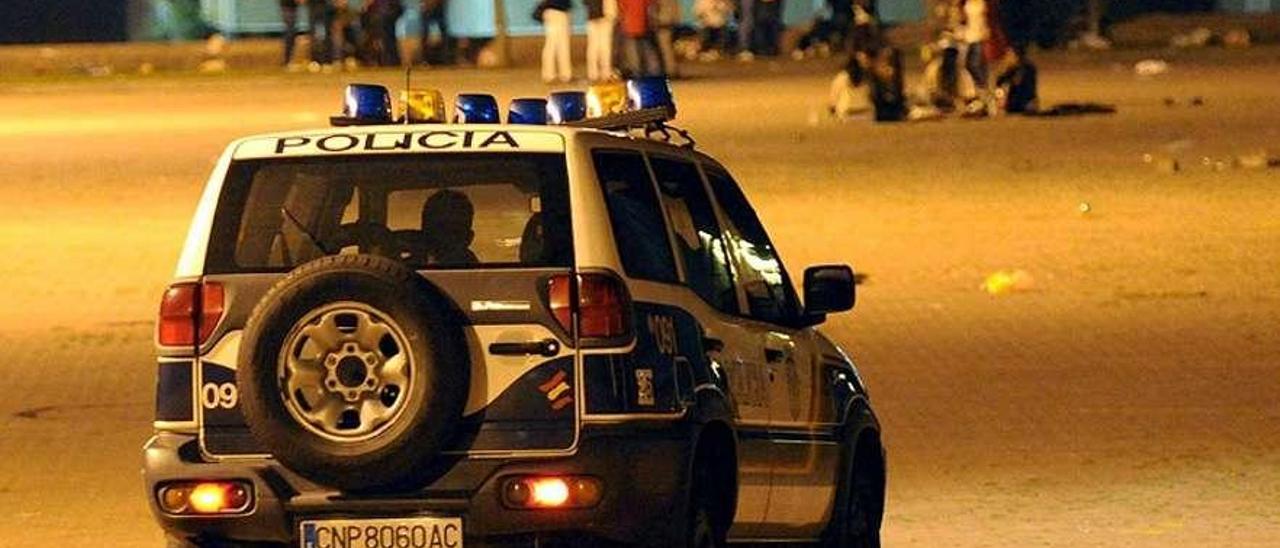 Un vehículo policial patrulla el recinto en el que se celebra el &quot;botellón&quot; en Pontevedra.