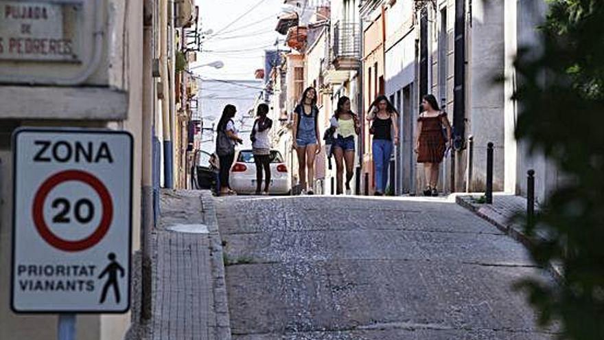 Un grup de noies camina pel centre del vial, de voreres estretes.