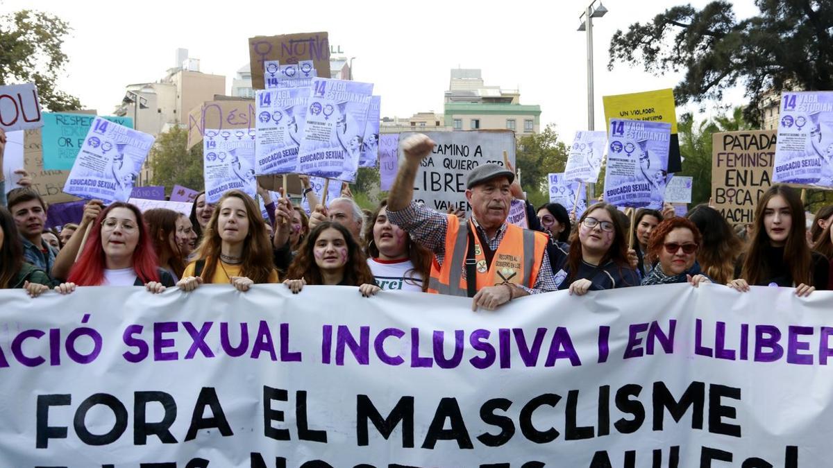 Estudiantes y un miembro de la Marea Pensionistas sujetando una pancarta en la concentración de este miércoles