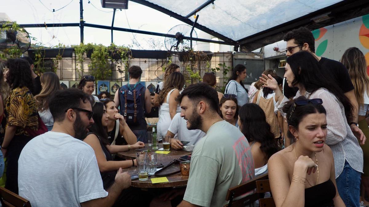 Jóvenes conversan y participan en el mercadillo benéfico organizado en Tel Aviv para recaudar dinero para los soldados.