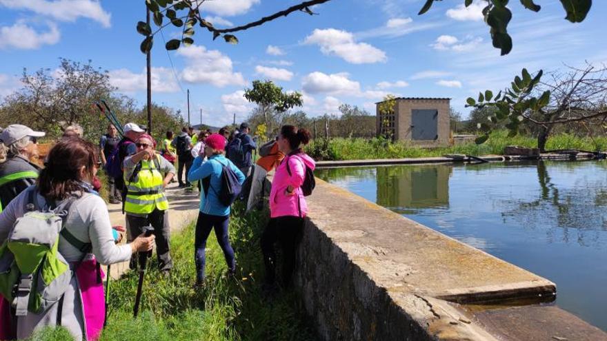 Los excursionistas hacen una parada junto a una balsa.