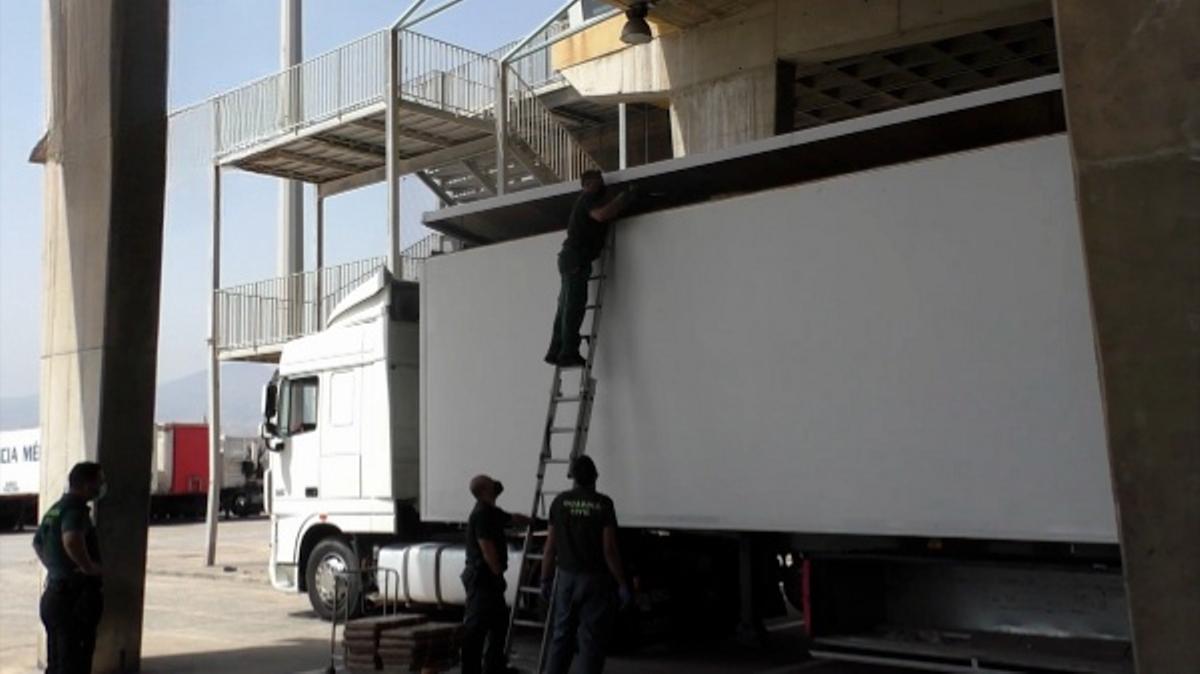 Agentes de la Guardia Civil revisan la droga oculta en el techo de un camión.
