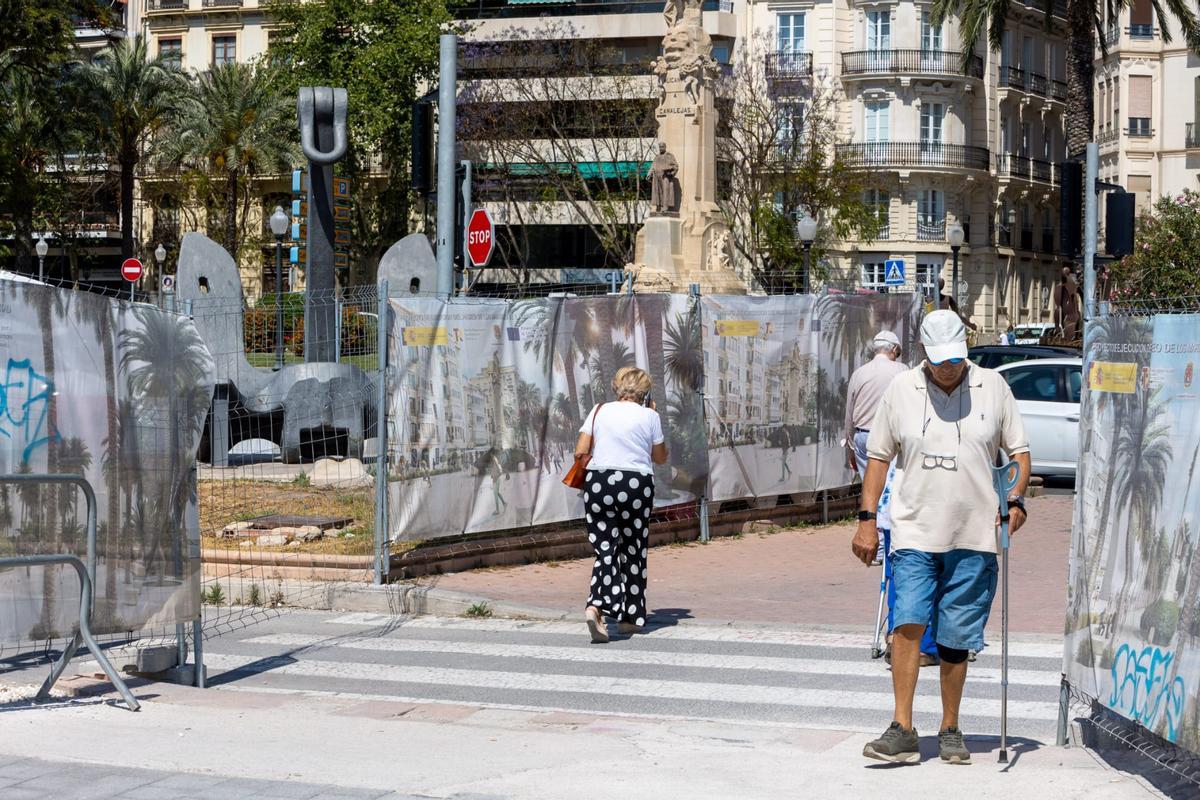 Varias personas pasan entre las interrumpidas obras, este lunes.