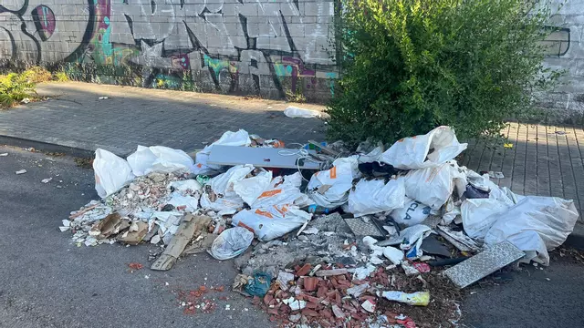 Una calle de L'Hospitalet se convierte en un vertedero ilegal de sacos con escombros de obra